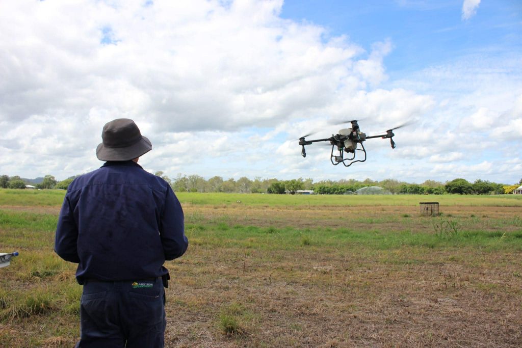 A pilot watching the spray drone take off